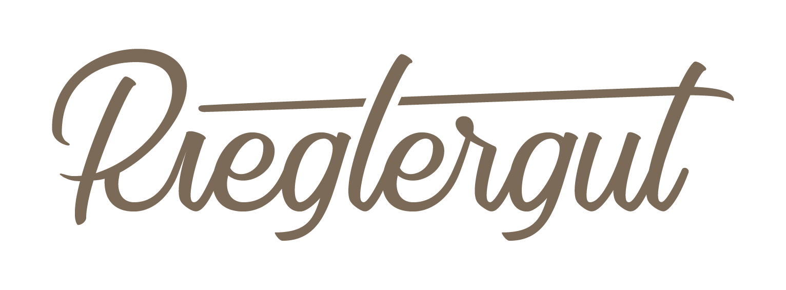 Das Wort „Rieglergut“, ideal für Ihre nächste Veranstaltungslocation oder Privatfeier, ist in brauner Kursivschrift geschrieben, wobei vom Buchstaben „g“ ein Strich ausgeht.